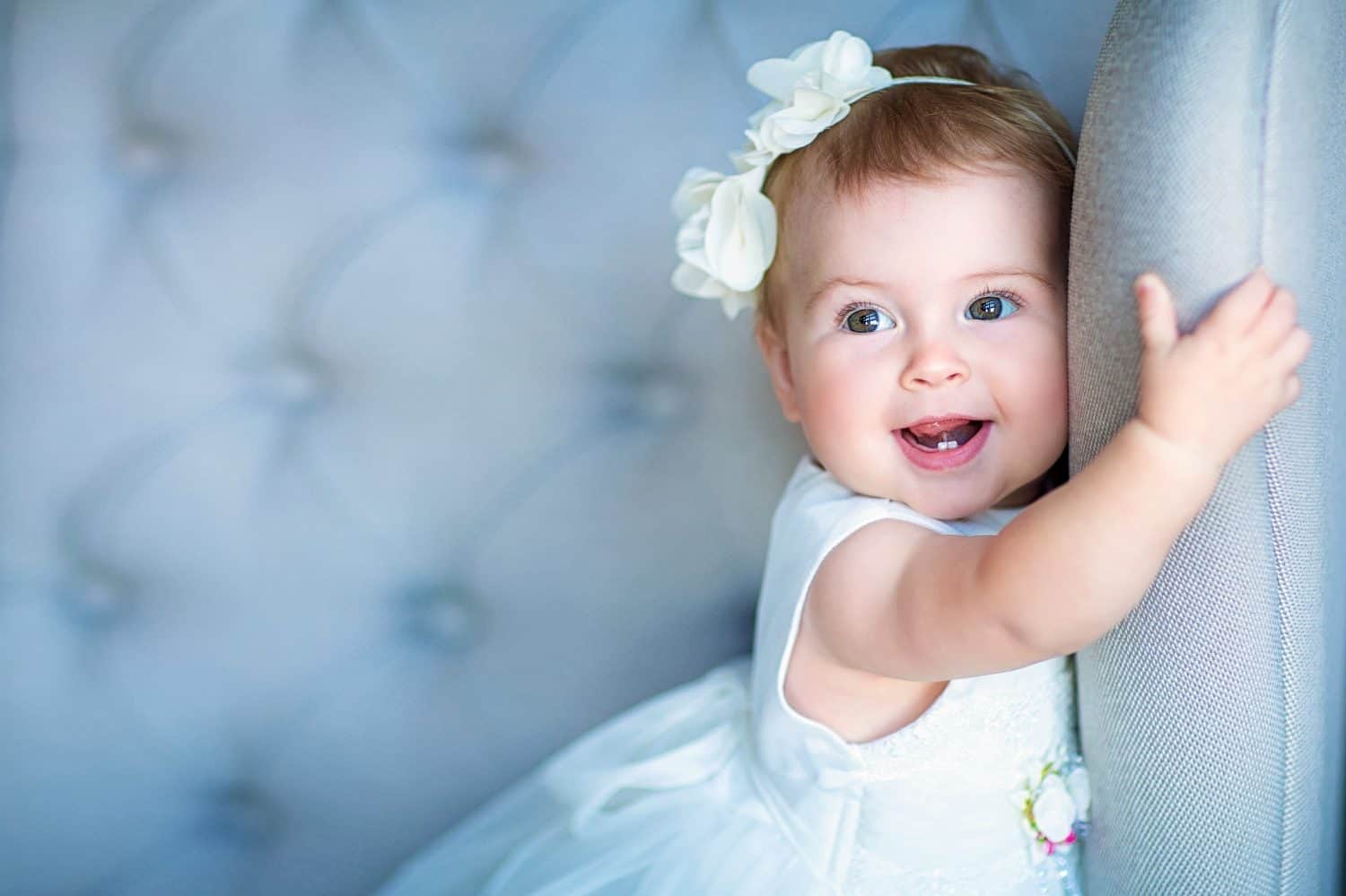 Image of sweet baby girl in a wreath, closeup portrait of cute 8 month-old smiling girl, toddler.Studio shooting