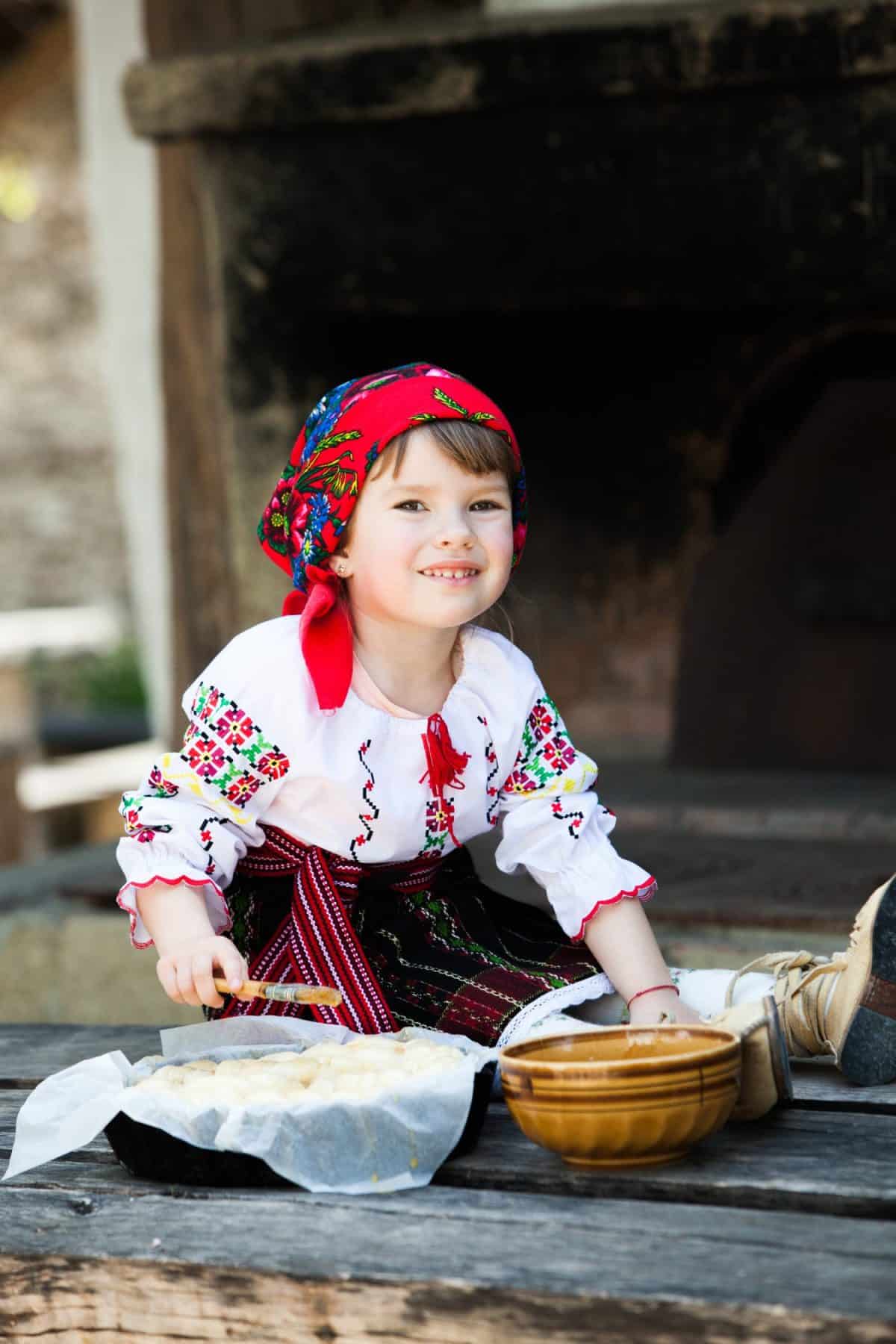 Little girl in traditional Romanian folk costume with embroidery. Girl in Romanian dress. Romanian folklore