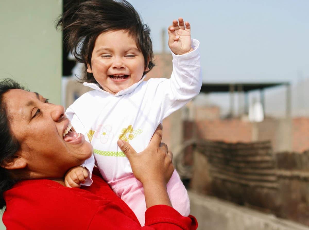 Tender portrait of native american woman playing with her little daughter.