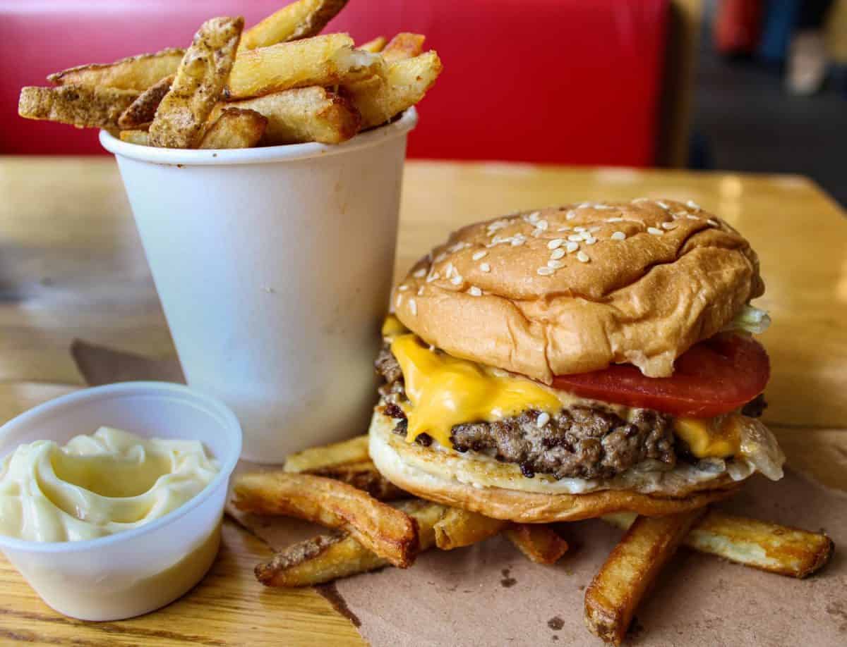 Five Guys Cheesy Hamburger and crunchy hand -cut fries with Mayo. Fast Food Restaurant meal.