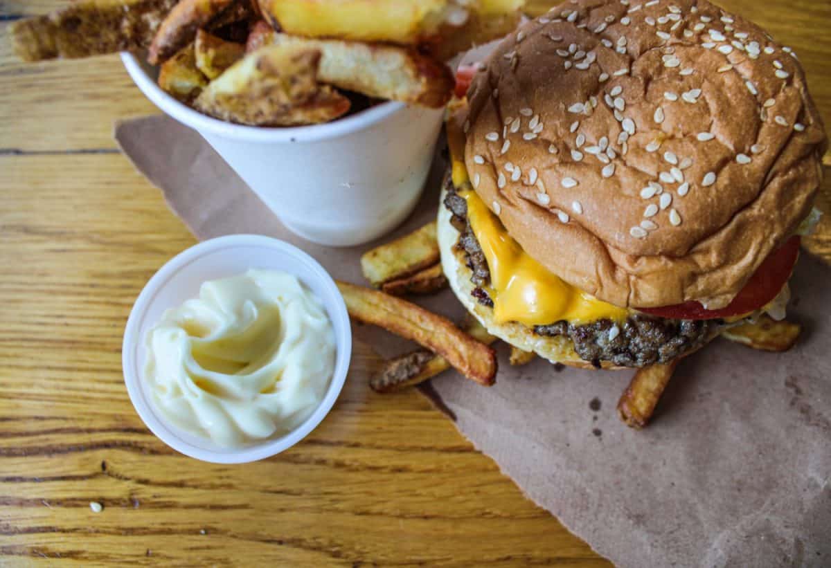 Cheesy Hamburger and crunchy hand-cut fries with Mayo at Fast Food Restaurant. Top view