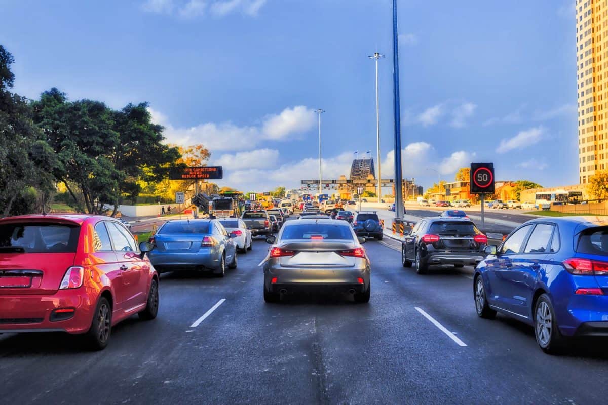 Western distributor motorway in Sydney packed with cars entering the Sydney harbour bridge from CBD between skyscrapers.