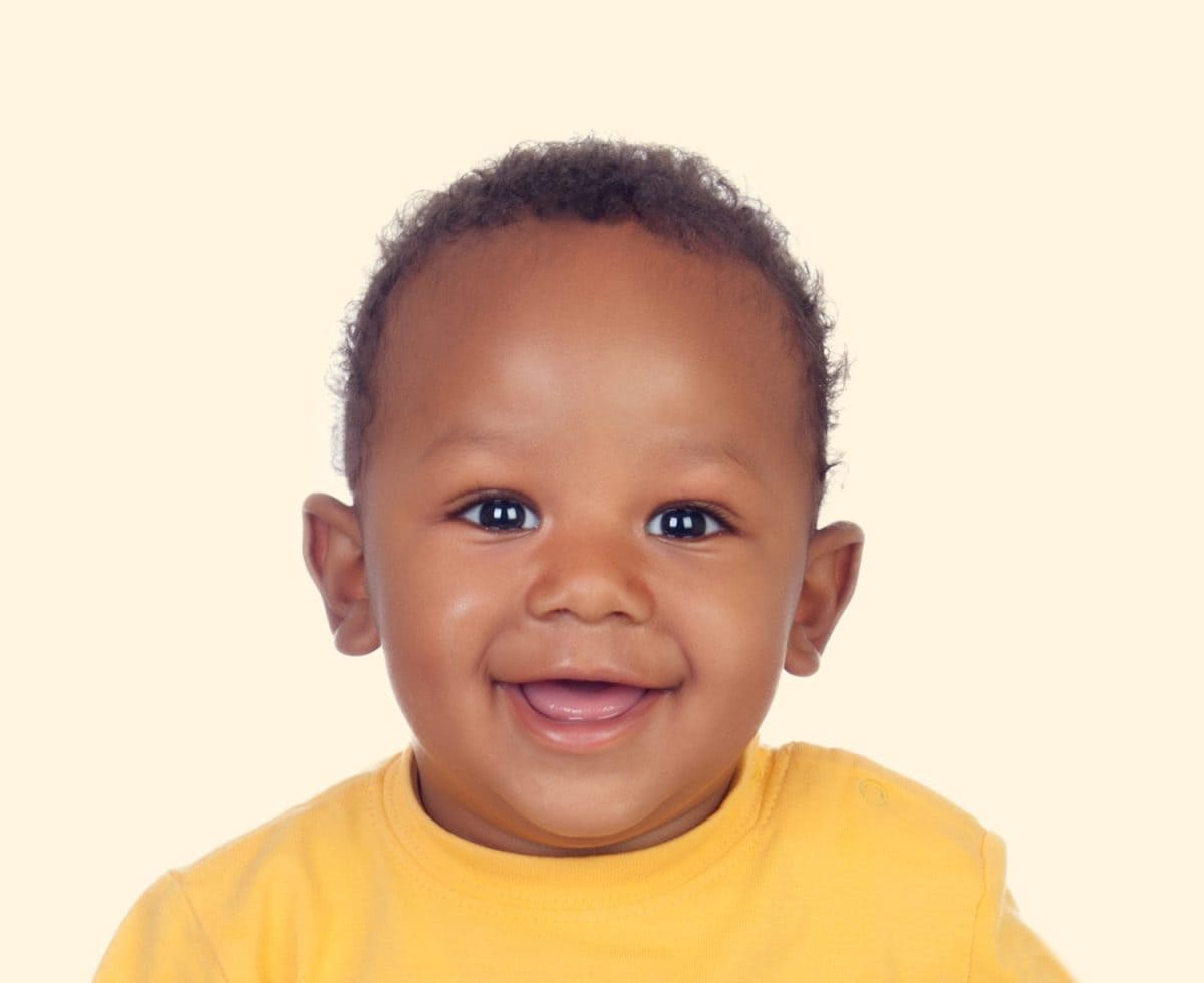 Adorable african baby with a beautiful smile on a yellow background