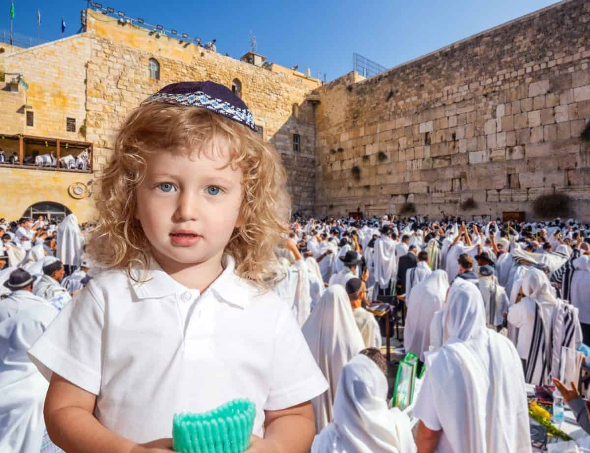 Llittle Jewish boy with side curls in yarmulke. Jews praying at the Western Wall. Ceremony at the Temple Mount in Jerusalem. The blessing of Cohenim.The concept of religious and photo tourism