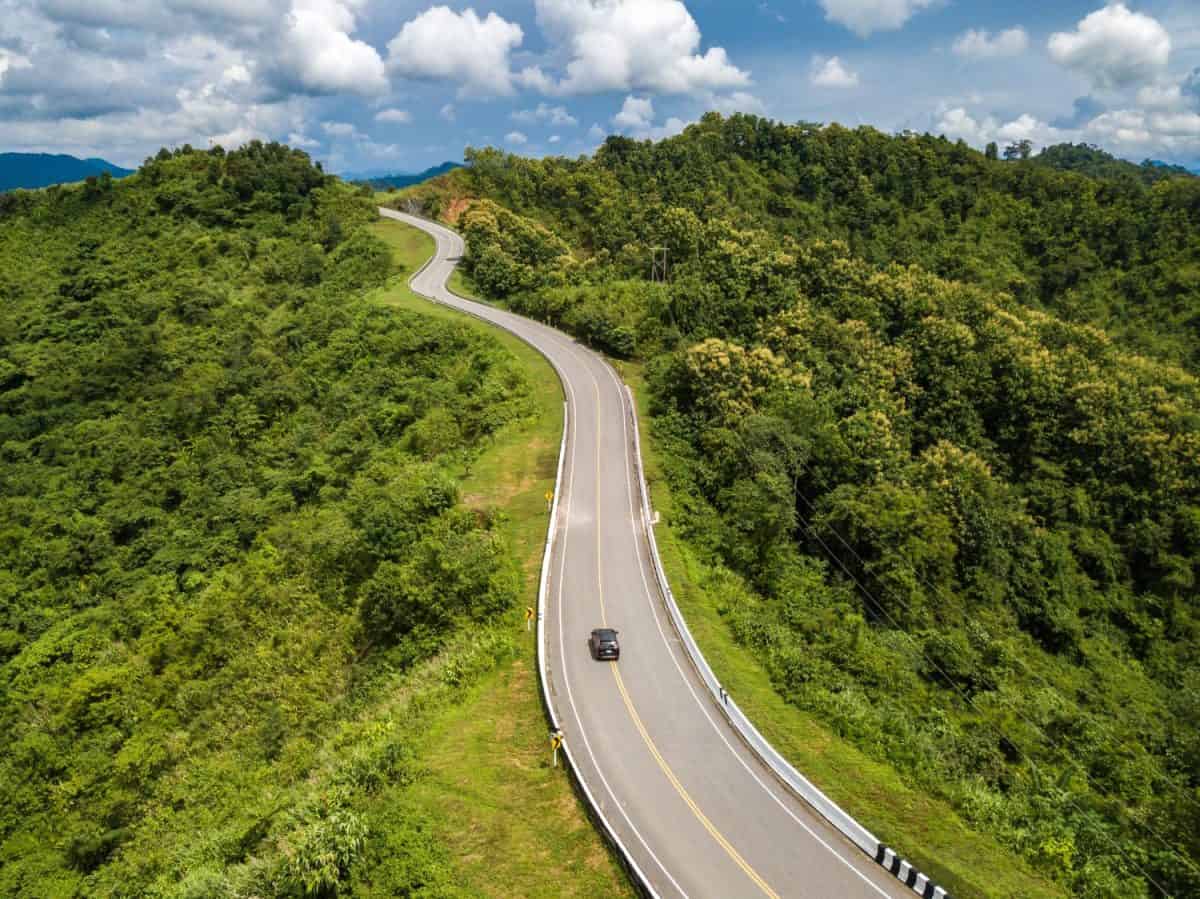 Aerial view of car driving on beautiful steep curved road (look like number 3) on the high mountain in Nan province, Thailand.