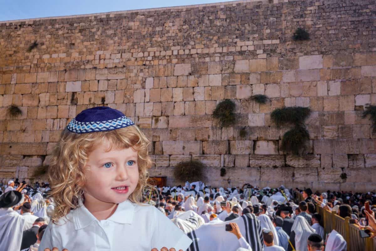 Charming little Jewish blond boy with blue eyes in a yarmulke. The blessing of the Cohen. Ceremony at the Temple Mount in Jerusalem. Jews praying at the Western Wall.