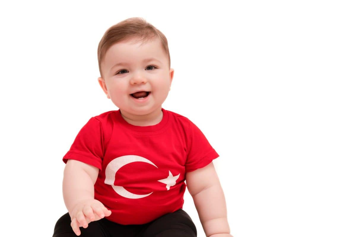 Portrait of happy little kid. Cute baby toddler with Turkish flag t-shirt. Adorable child isolated on white.