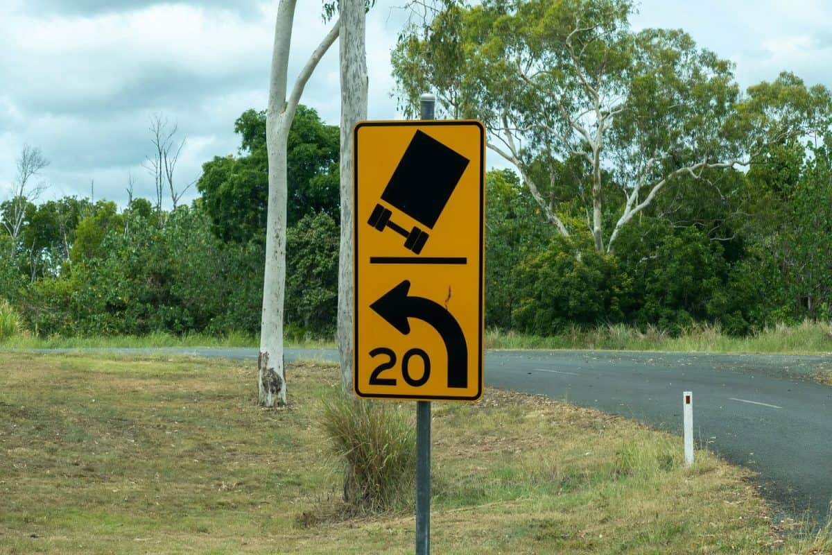 Warning road sign of sharp bend in country road