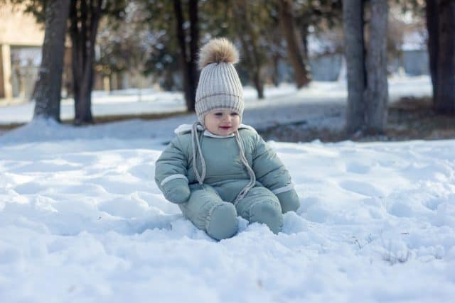 A beautiful photoshoot of a cute Armenian baby with blue eyes in the snowy park