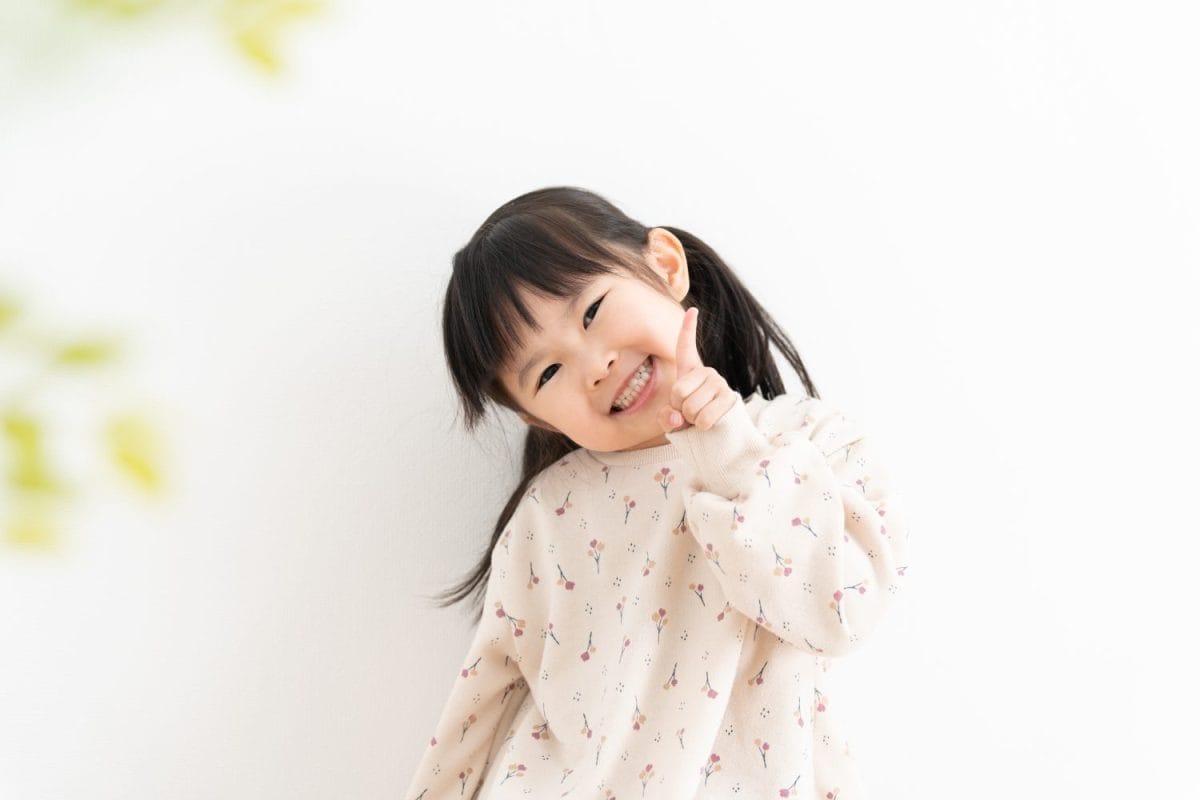 Asian child pointing on white background