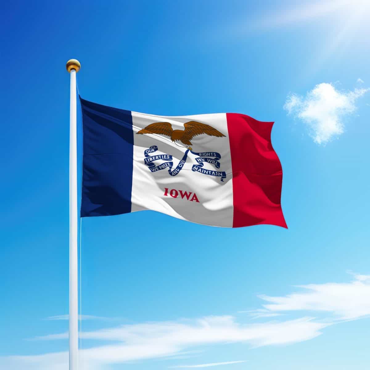 Waving flag of Iowa is a state of United States on flagpole with sky background.