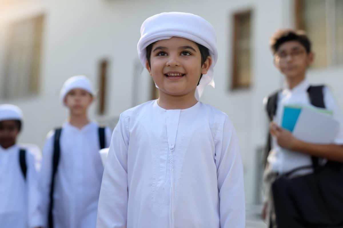 Young Middle Eastern Arab boy student with blurred schoolmates, indian and Arabic classmates