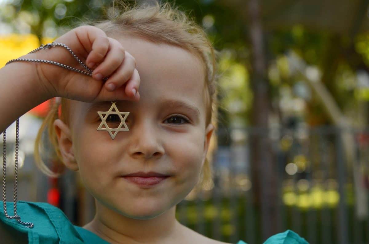 Portrait of a little girl, Child looking through the Star of David. Megan Davin in the arms of a girl. Children of Israel.