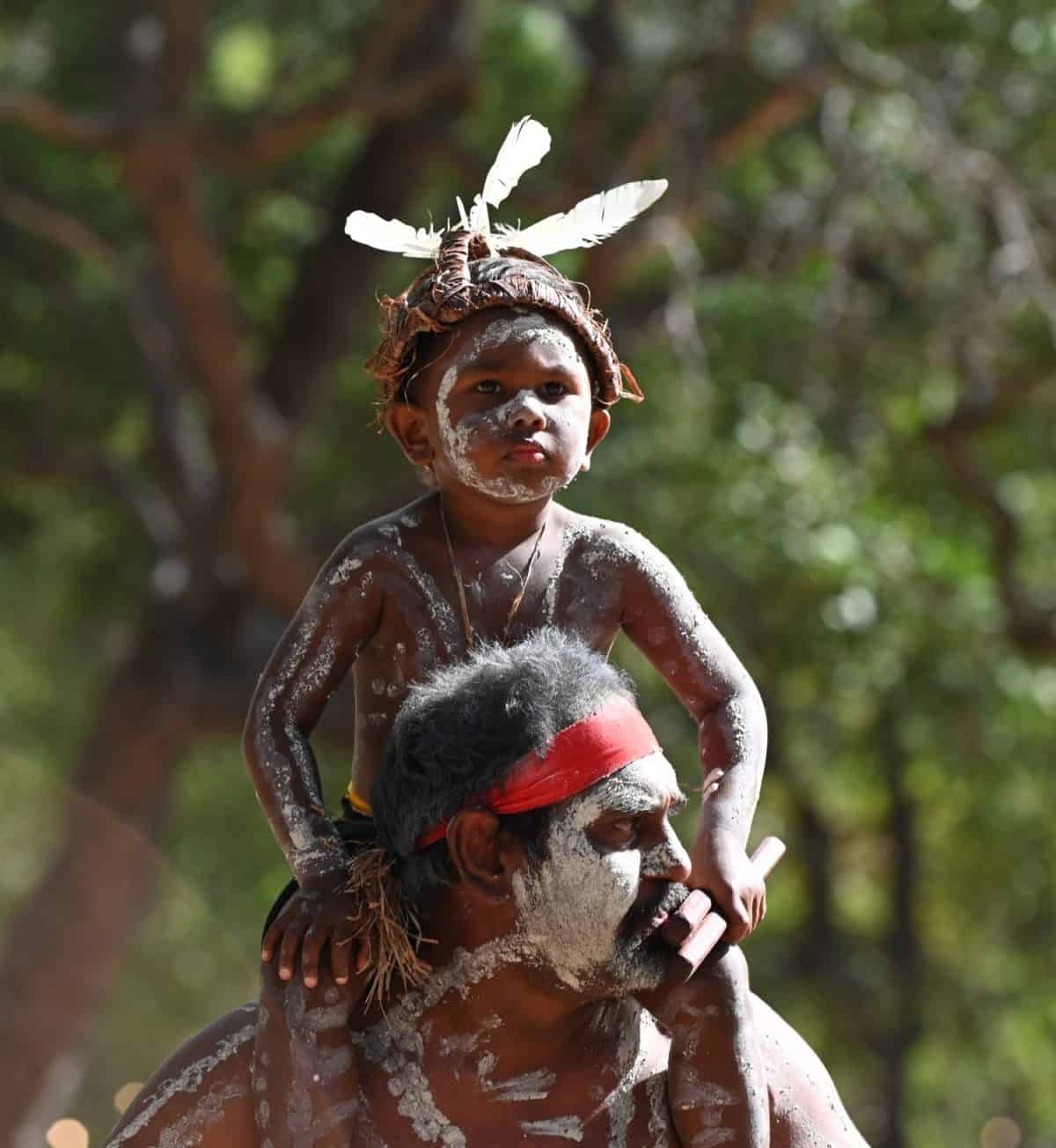 LAURA,QLD - JULY 08 2023:Indigenous Australians father and son in Laura Quinkan Dance Festival Cape York Australia. Ceremonies combine dance, song, rituals, body decorations and costumes