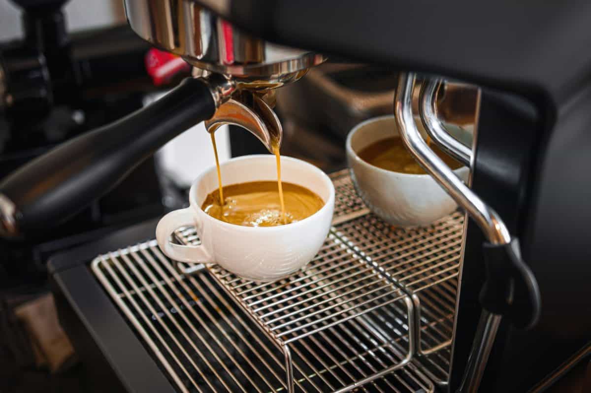 Professional espresso machine while preparing espressos coffee cup in a coffee shop. Close-up of espresso pouring from the coffee machine