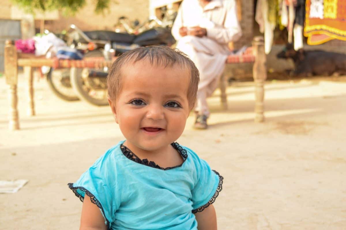 Portrait of 1 Year Pakistani baby girl. Pakistani baby girl playing in and eating against natural background. Pakistani kids. Pakistani 1 year baby. Asian baby girl. Happy kid. Village babies girl.