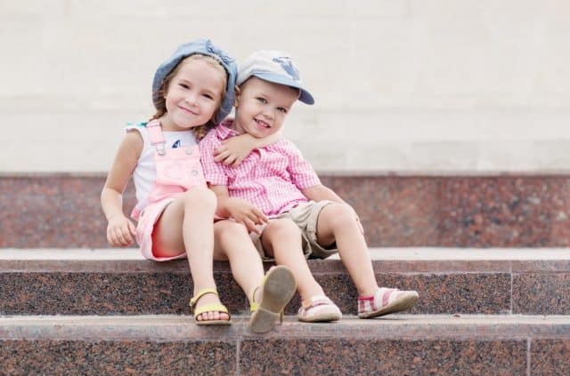 Happy toddler children sit on the steps outdoors