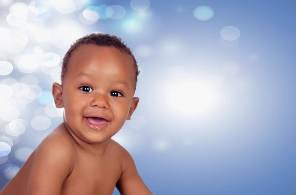 Baby with one years old doing funny gestures with surprised expression on a blue background