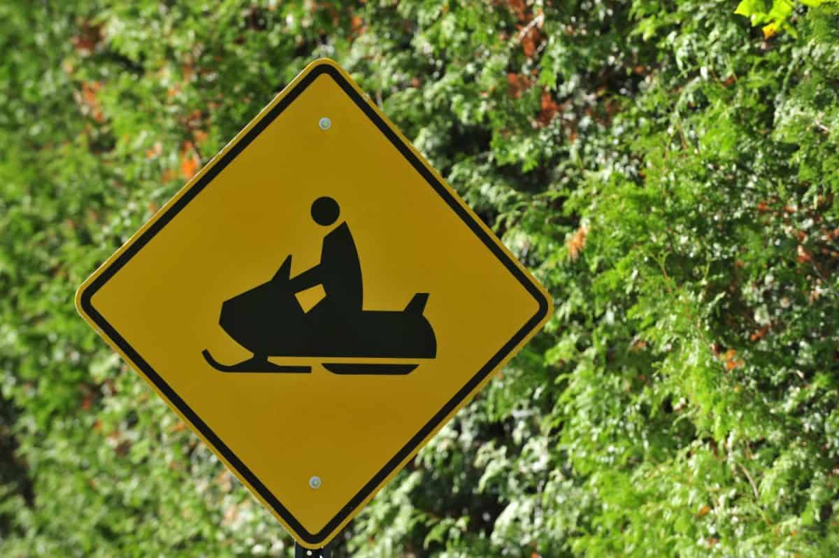 Snowmobile crossing road sign