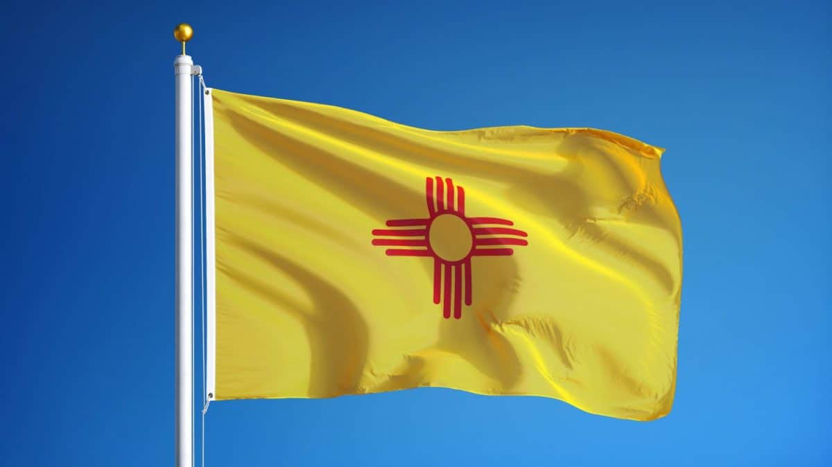 New Mexico flag waving against clean blue sky, close up, isolated with clipping path mask alpha channel transparency