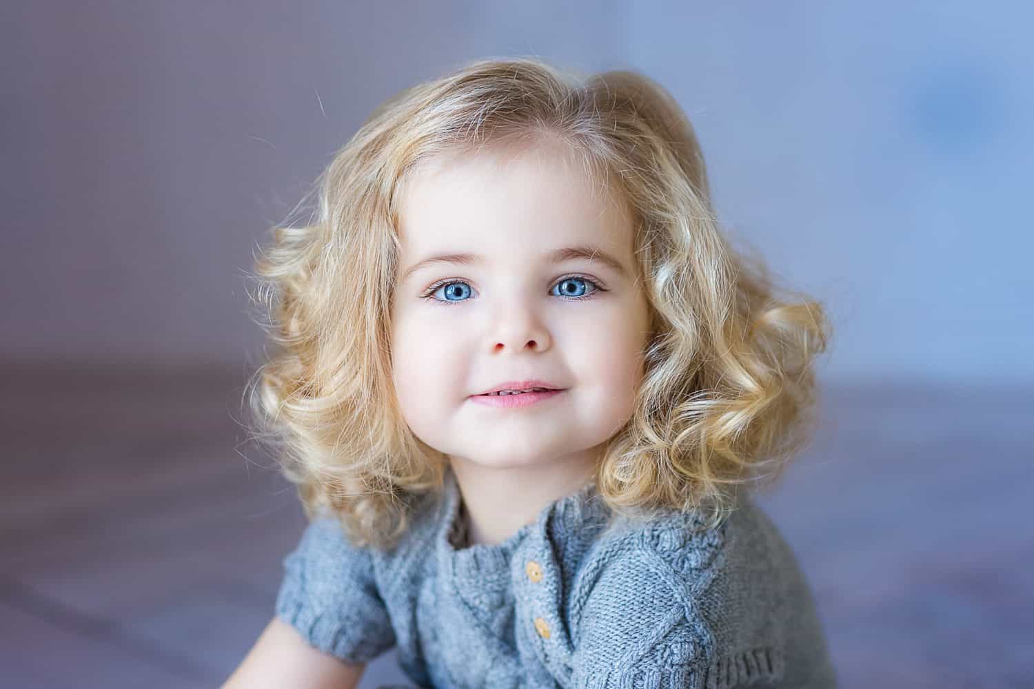 Beautiful toddler girl smiling. Close-up portrait. Blue eyes.