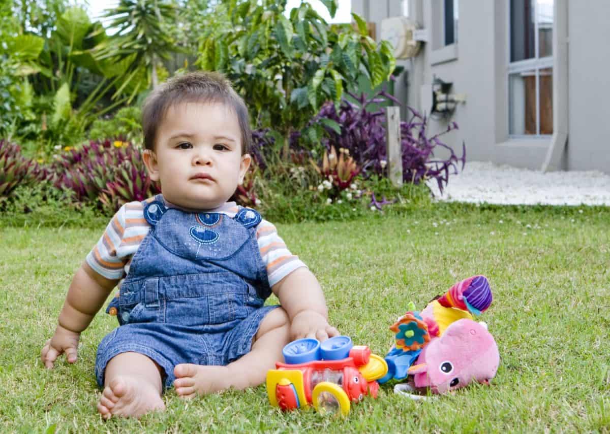 a baby boy in a natural setting in a garden