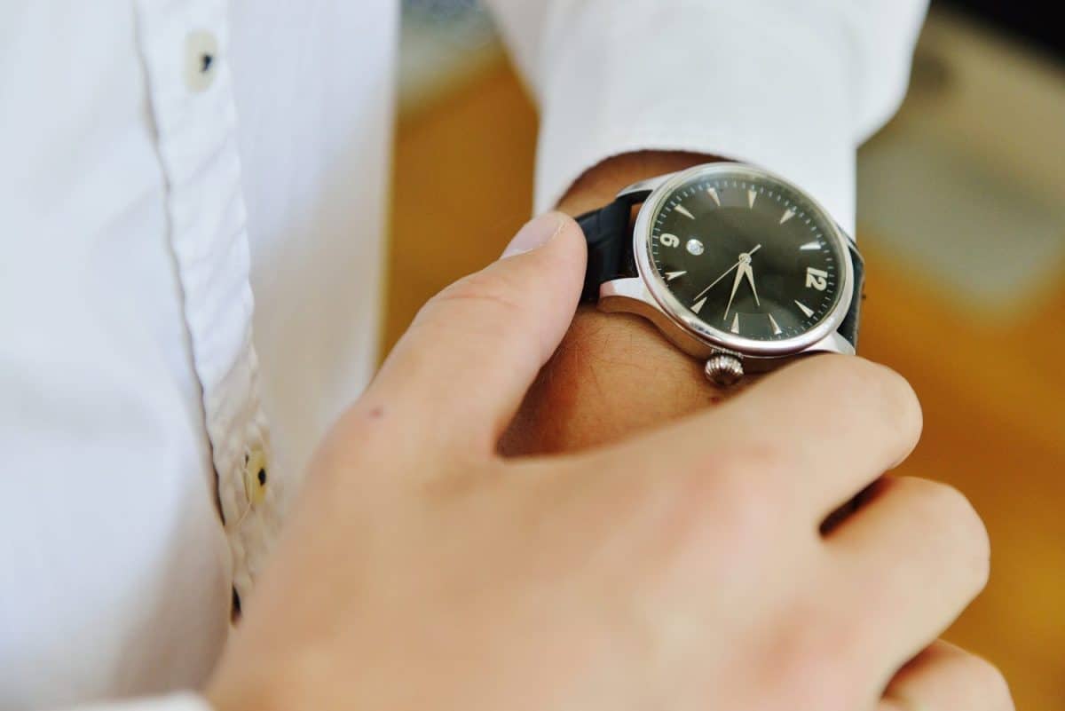 man looks at the black classic watch. watch with black dial