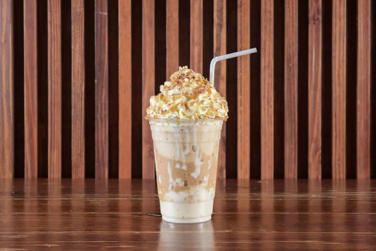 Cold coffee drink frappe (frappuccino), with whipped cream and caramel syrup