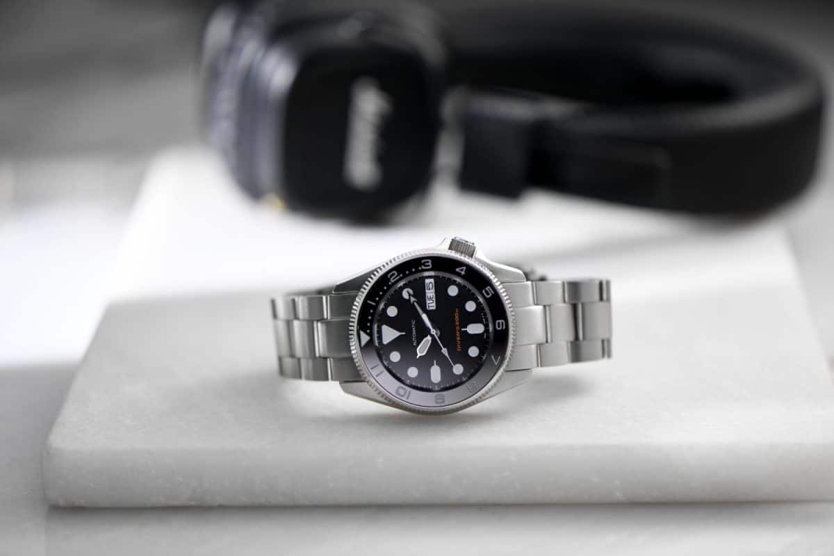 Stainless steel sport divers watch on white marble background