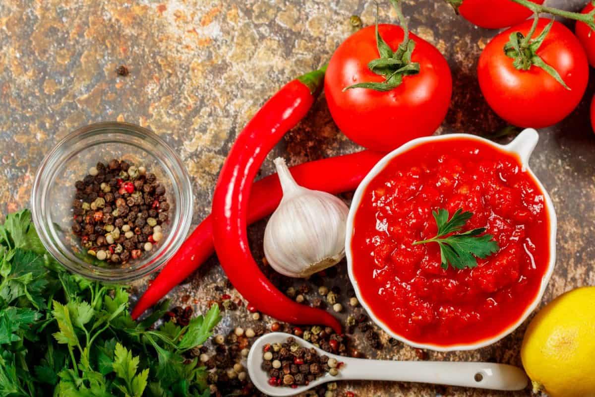 Salsa Sauce. Spicy, colorful Mexican salsa sauce with hot peppers and tomatoes on a dark background.Classic homemade Italian tomato sauce for pasta pizza in on wooden background.