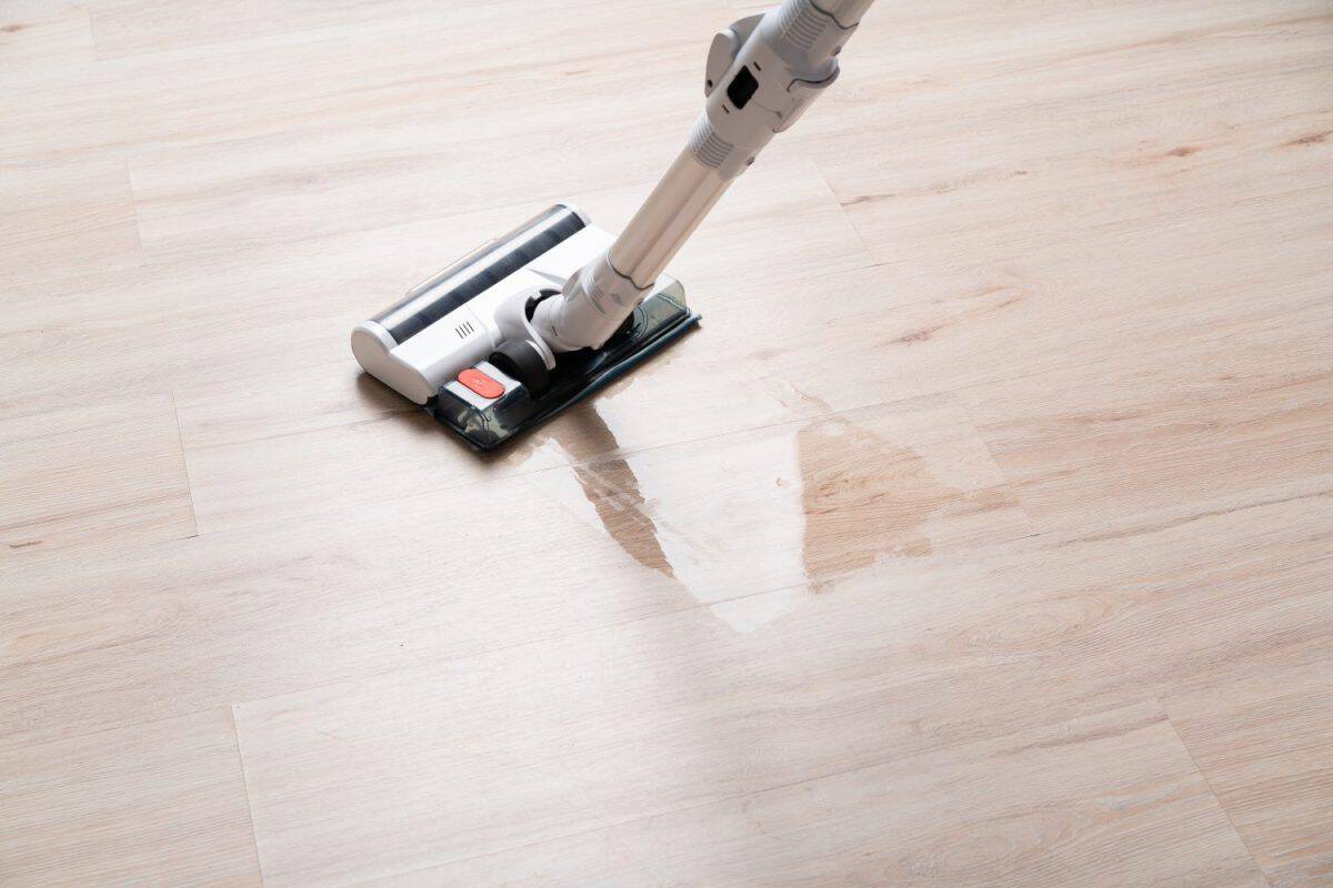 Modern vacuum cordless vacuum cleaner with water nozzle for cleaning floors. Close-up of vacuum cleaner and damp footprint on floor. House cleaning. I Loved My Dyson, But These 8 Vacuum Brands Are a Better Deal