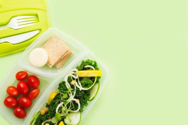 A tupperware lunch box separates salad ingredients.