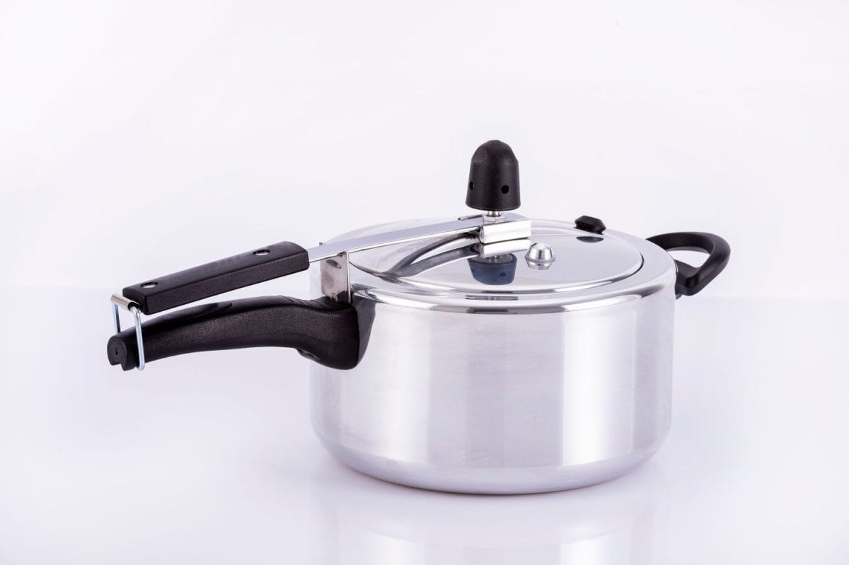 Practical silver pressure cooker on neutral background