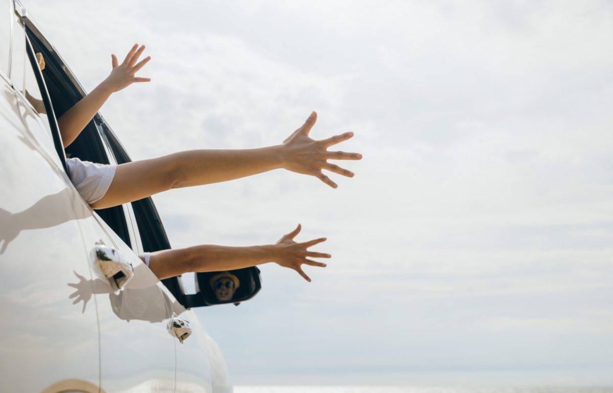 Father, mother and children raise hand wave goodbye, People having fun on road trip, vacation holiday, Happy family sitting in car waving hands travel outside car windows going to beach for travel