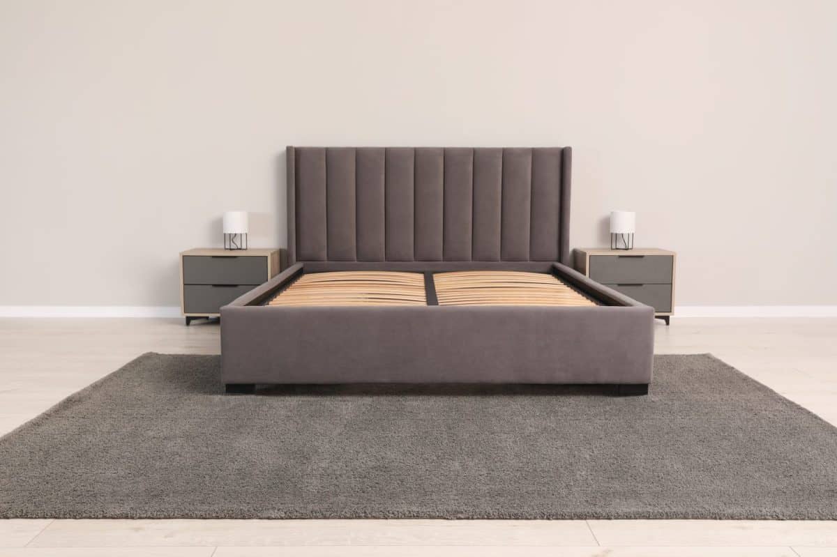 Comfortable bed with storage space for bedding under slatted base in room