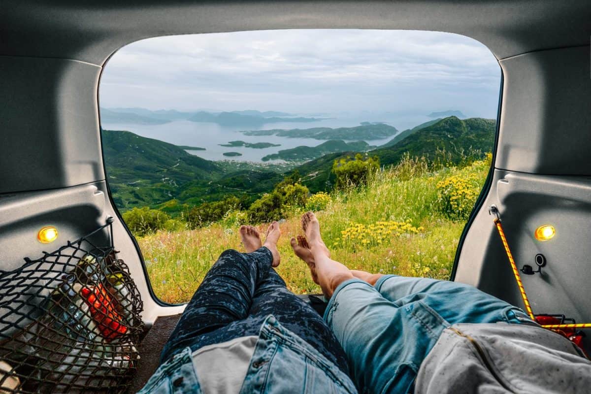 Low section of people in car looking at beautiful mountain landscape