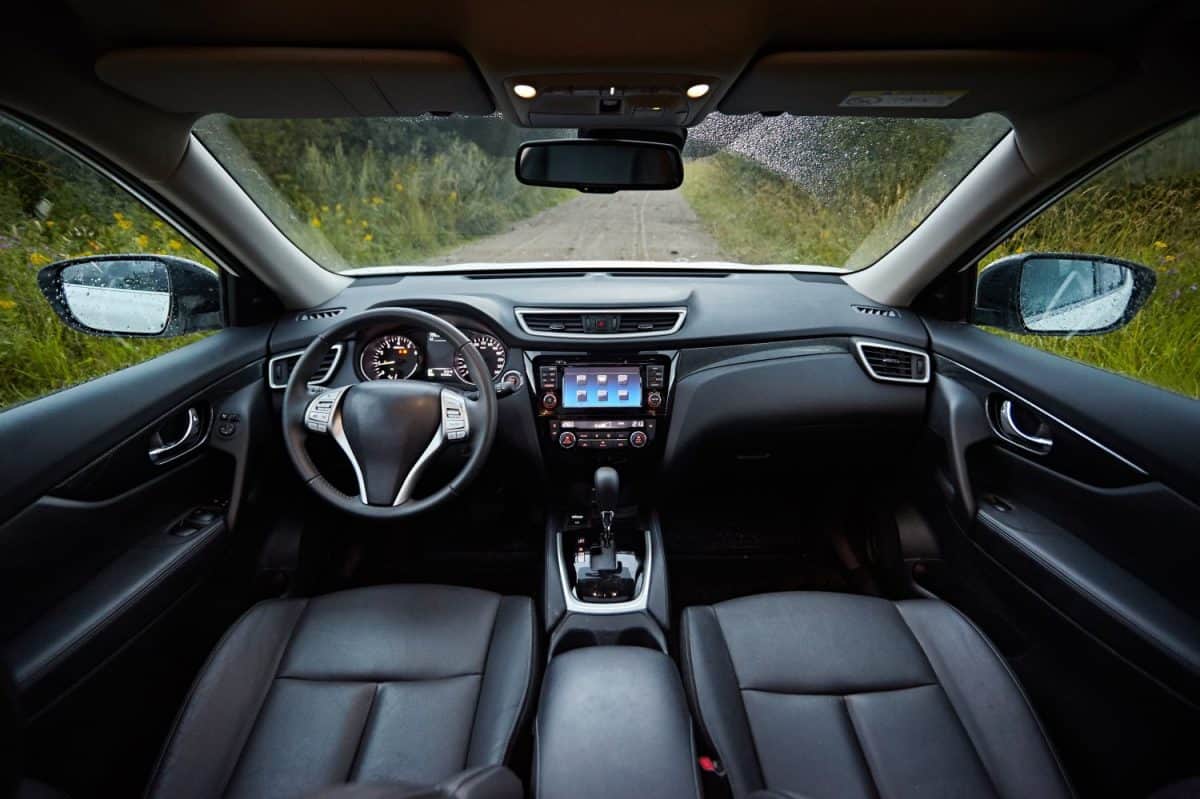 Dark car interior - steering wheel, shift lever and dashboard. Car modern SUV inside.