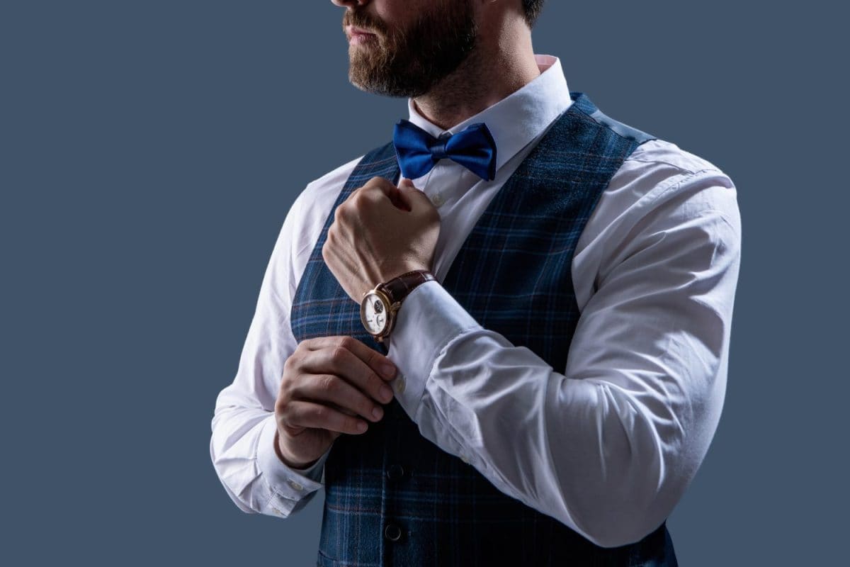 Man in bowtie and watch. Elegant watch accessory. Time. Elegant gentleman isolated on grey. Male accessory. Gentleman in bowtie show luxury watch. Expensive time wrist watch. Fashion Accessory