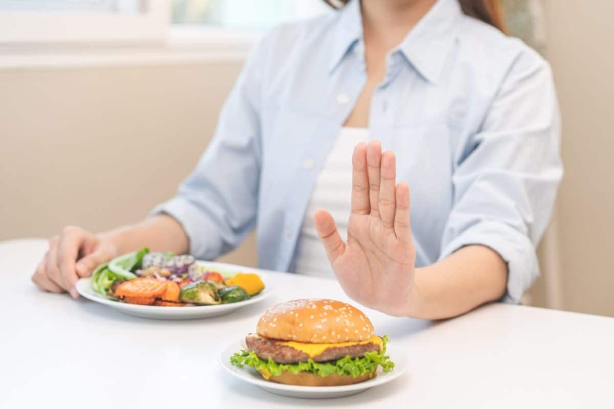 Diet concept, asian young woman hand reject eat burger, hamburger on plate, push out or deny to eat fast, junk food choose green vegetable salad, girl eat low fat for good healthy, getting weight loss. In-N-Out vs. Shake Shack: Who Actually Has the Better Burger?