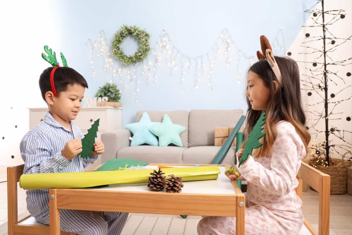 Cute little children creating Christmas decor at home