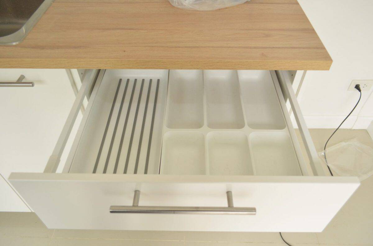 IKEA FURNITURE WHITE DRAWER TRAY OF SPOON FORK KNIFE STICK TEA SPOON IN COUNTER WOOD TOP IN THE KITCHEN INTERIOR DECORATION LOOK NICE AND TIDY