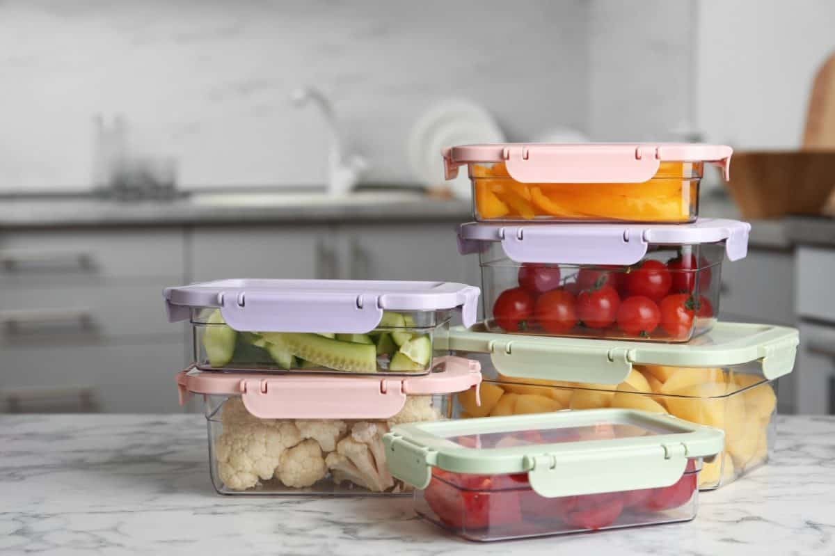 Boxes with fresh raw vegetables on table in kitchen