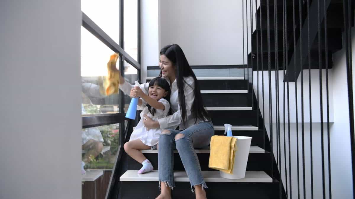 Cleaning concept. Mother and daughter are helping to wipe the glass.