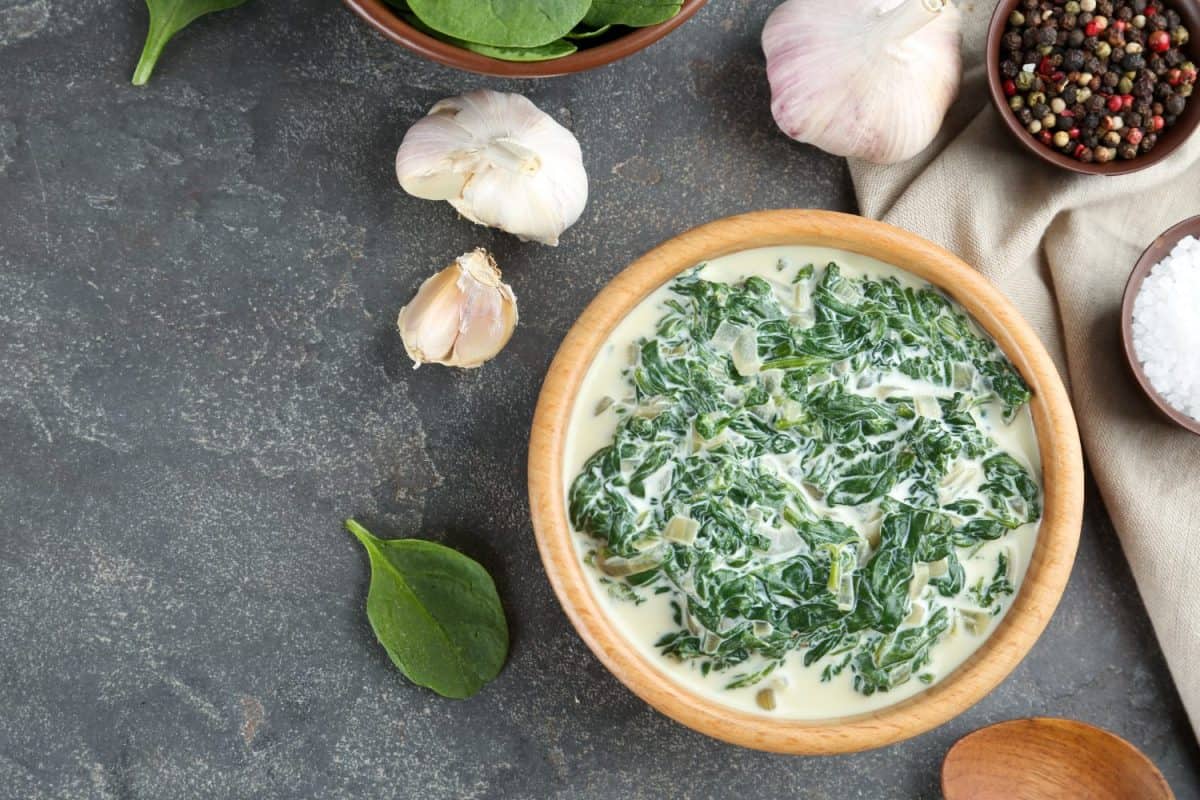 Tasty spinach dip on grey table, flat lay