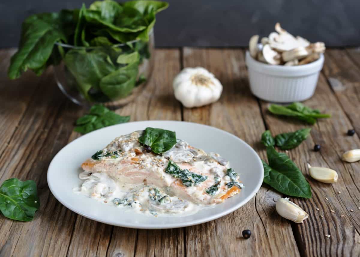 Salmon fillet by Florentine with creamy sauce on the top, mushrooms, garlic and spinach as main ingredients