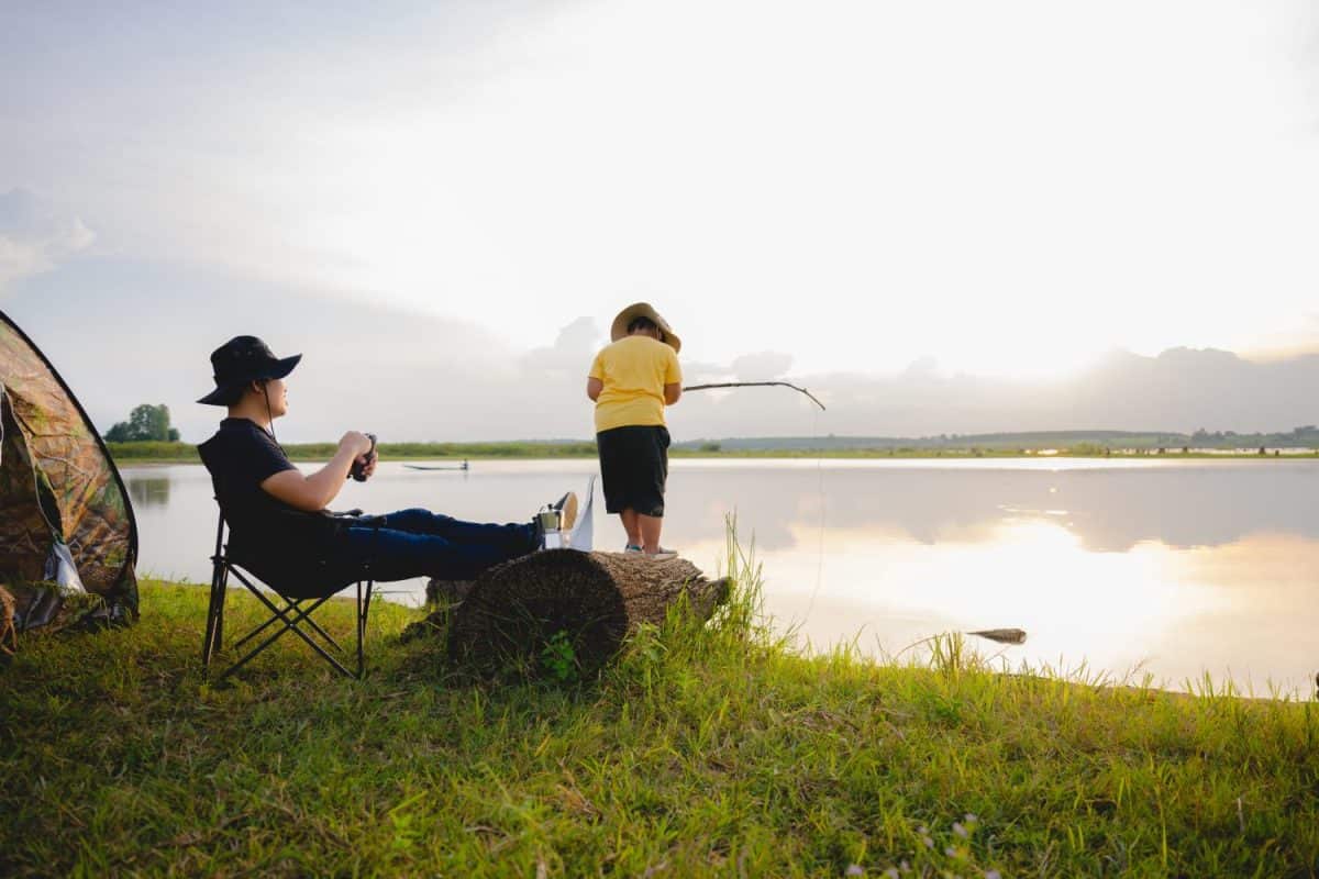 Asian father and son traveler and son camping together happy family In front of the tent camp in the evening against the lake or river floor. Young Asians enjoying camping. Are These Japanese Parenting Tactics Better Than How Americans Raise Children?