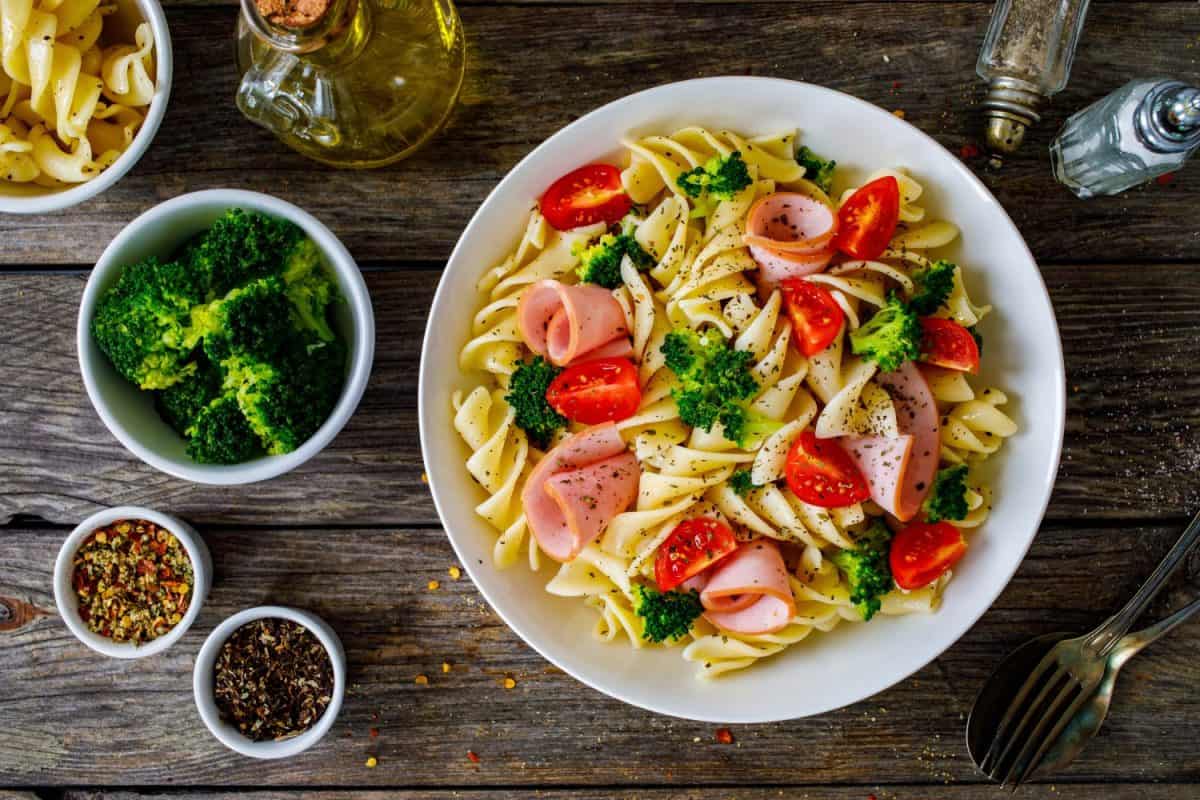 Pasta with ham, broccoli and cherry tomatoes on wooden table. I Used to Only Eat Boar's Head Deli Meat, But These 8 Brands Are Just as Good