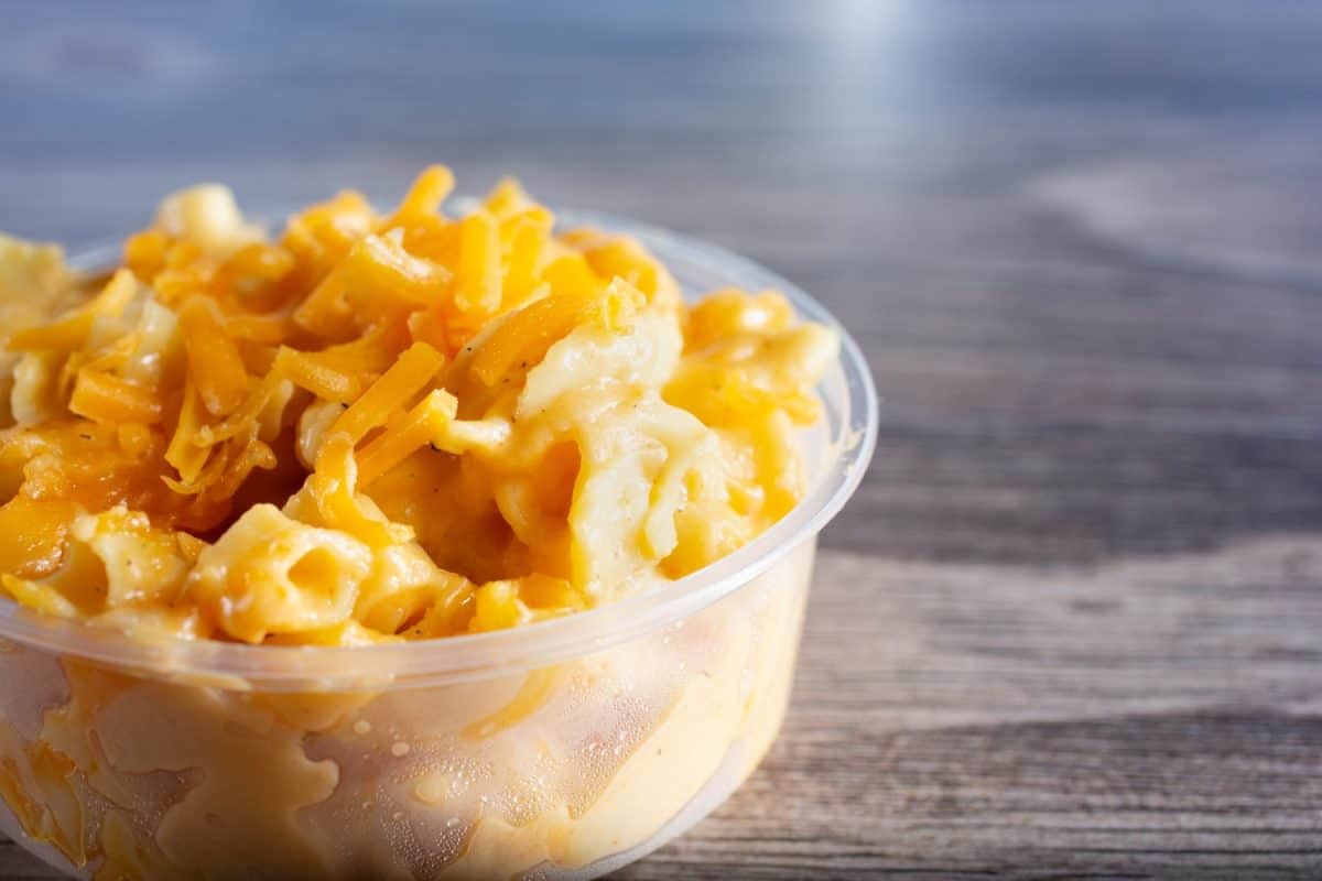 A closeup view of a plastic container of macaroni and cheese.