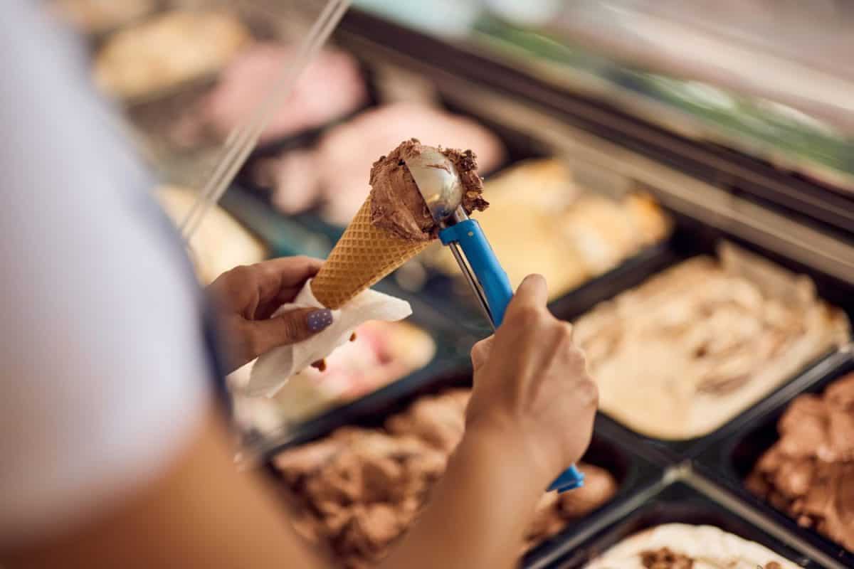 Ice cream chocolate in a cone, put with a scooper.