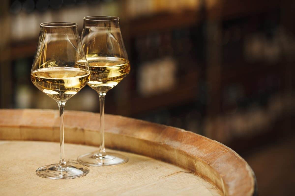 Two Glasses of White Wine on Wooden Barrel, Close up. Forget Chardonnay, These 12 White Wines Are Better